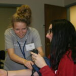 CNA students taking blood pressure